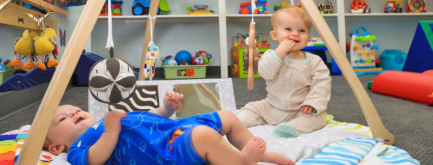 Two happy infants playing in the infant room